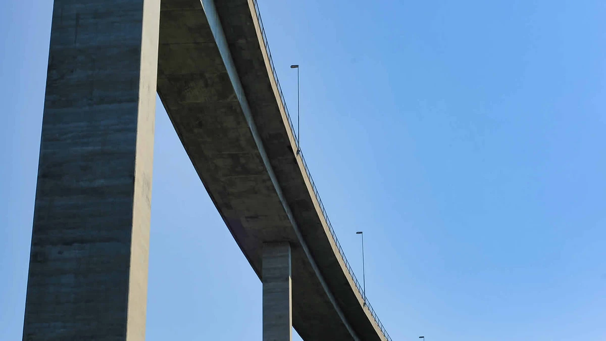 Smart infrastructure project, a concrete bridge against a blue sky.
